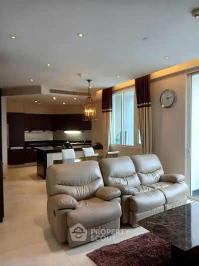 Luxurious open-plan living room with plush leather sofas and modern kitchen