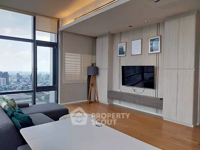 Modern living room with city view, stylish decor, and wall-mounted TV