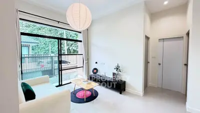 Modern living room with large window and stylish decor in a bright, open space.