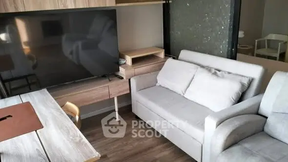 Modern living room with sleek furniture and large TV, perfect for relaxation.