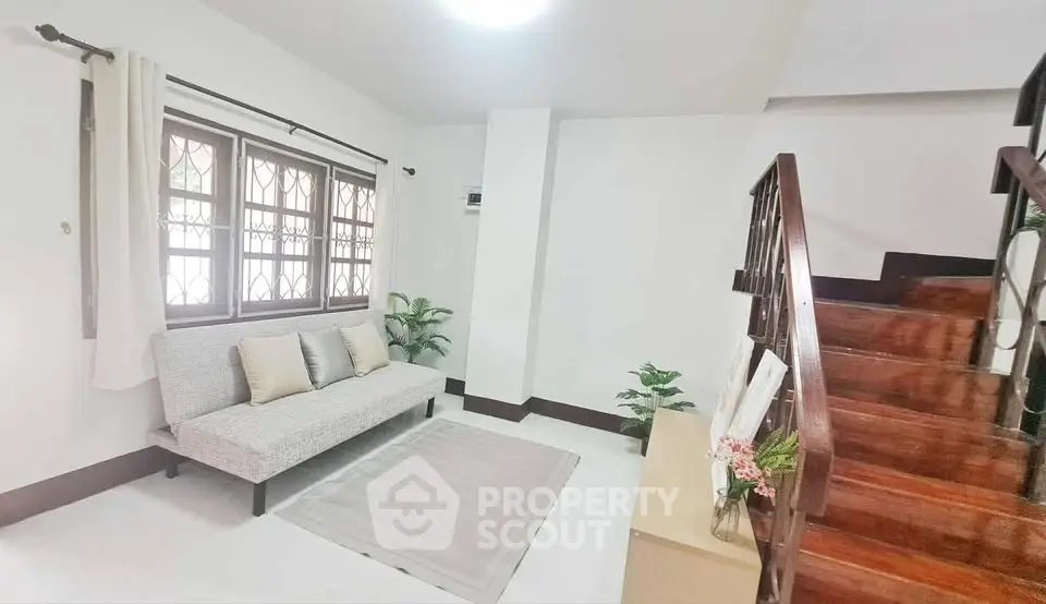 Cozy living room with modern decor and wooden staircase