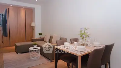 Modern living room with cozy sofa and dining area, perfect for entertaining guests.