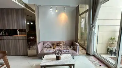 Stylish living room with modern decor and large windows opening to a balcony, perfect for urban living.