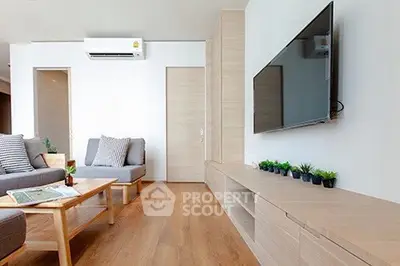 Modern living room with sleek wooden flooring and wall-mounted TV, perfect for relaxation.