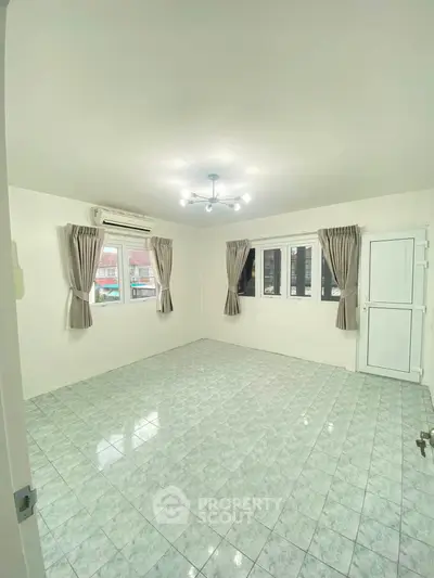 Spacious unfurnished room with tiled flooring and large windows for natural light.