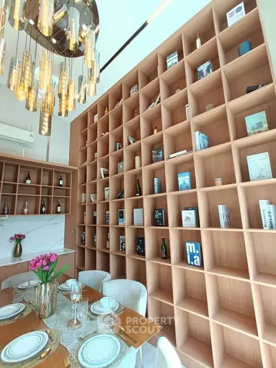 Luxurious dining room with elegant chandelier and floor-to-ceiling bookshelf