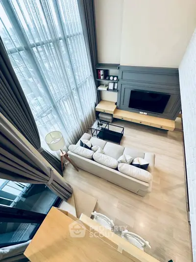Stunning high-ceiling living room with large windows and modern decor
