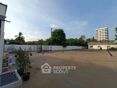 Spacious outdoor area with potential for development, featuring clear skies and lush greenery.