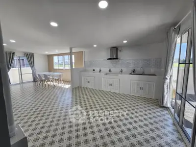 Spacious open-plan kitchen and dining area with modern design and ample natural light.