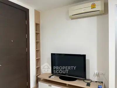 Modern living room corner with TV and air conditioner, perfect for cozy relaxation.