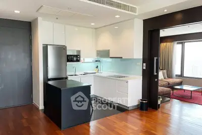 Modern open-layout kitchen with sleek appliances and adjacent cozy living area.