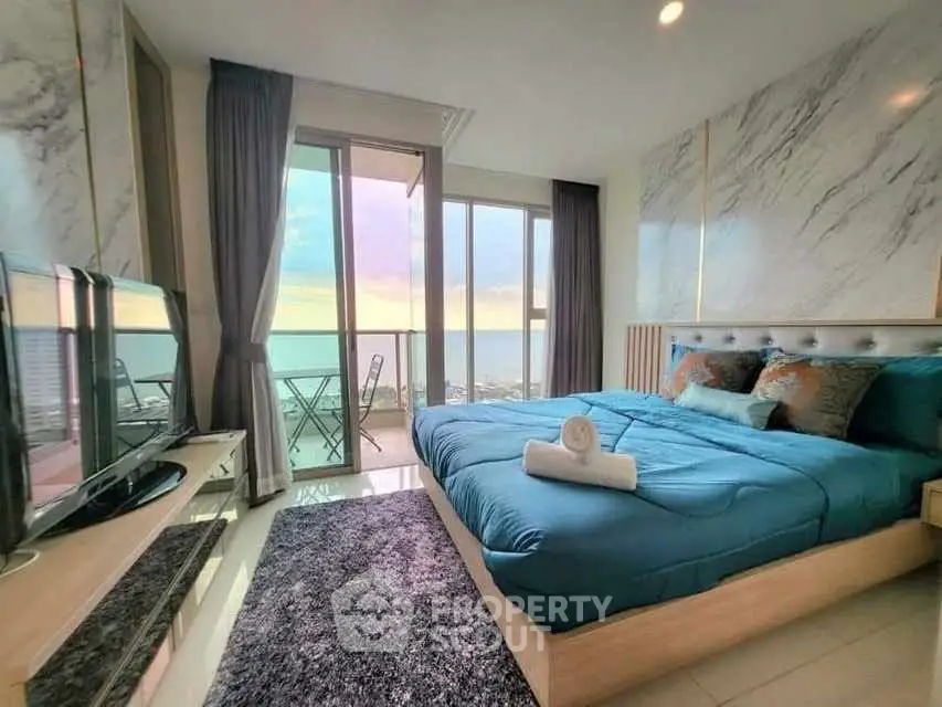 Luxurious bedroom with ocean view and modern decor, featuring a cozy bed and stylish furnishings.