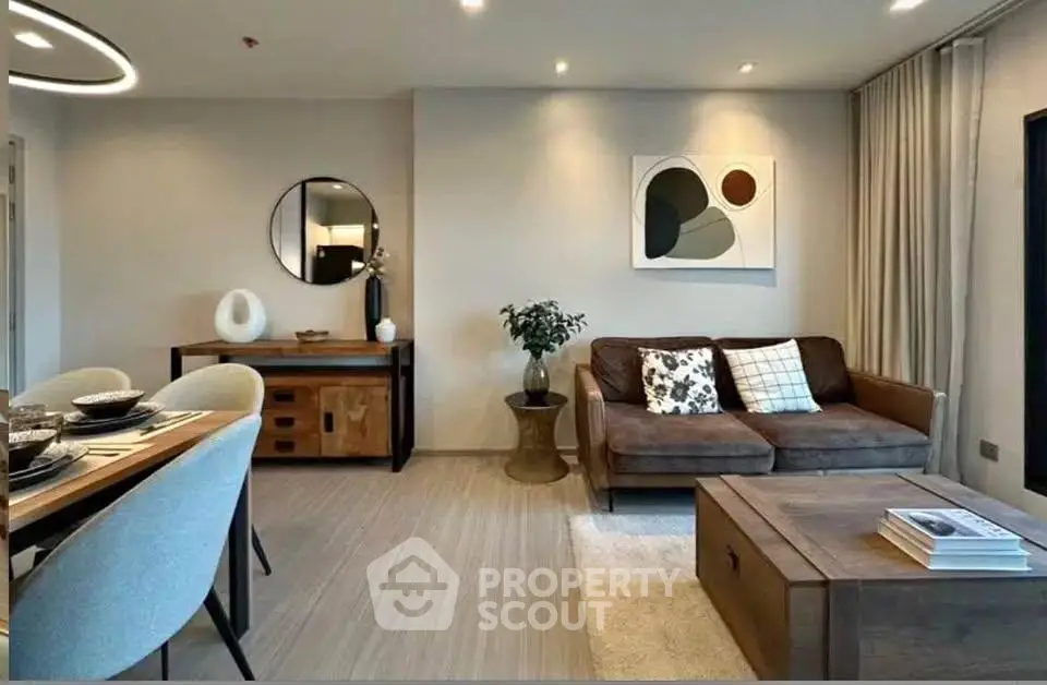 Modern living room with stylish decor and dining area, featuring contemporary furniture and elegant lighting.