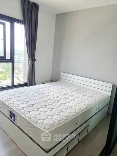 Modern bedroom with large window and stylish bed frame, offering a bright and airy atmosphere.