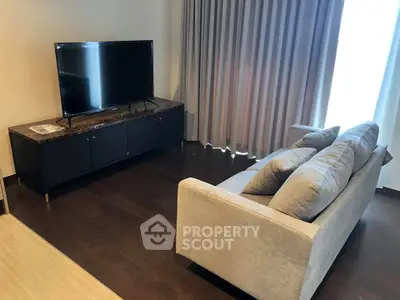 Cozy living room with modern sofa and large TV, perfect for relaxation.