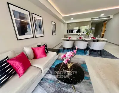 Luxurious modern living room with elegant decor and open dining area.