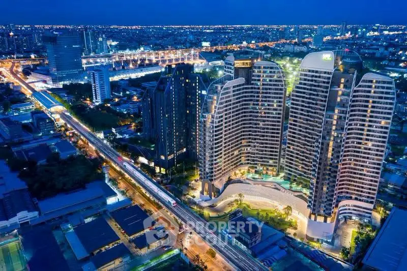 Stunning aerial view of modern high-rise buildings in a vibrant cityscape at night.