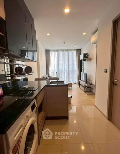 Modern open-layout kitchen and living room with sleek appliances and stylish decor.