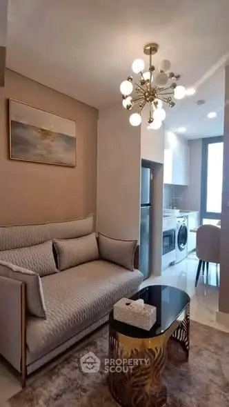 Stylish modern living room with elegant chandelier and cozy sofa in a contemporary apartment.