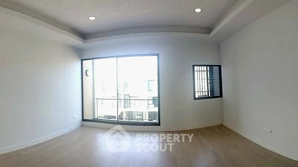 Spacious empty living room with large windows and wooden flooring