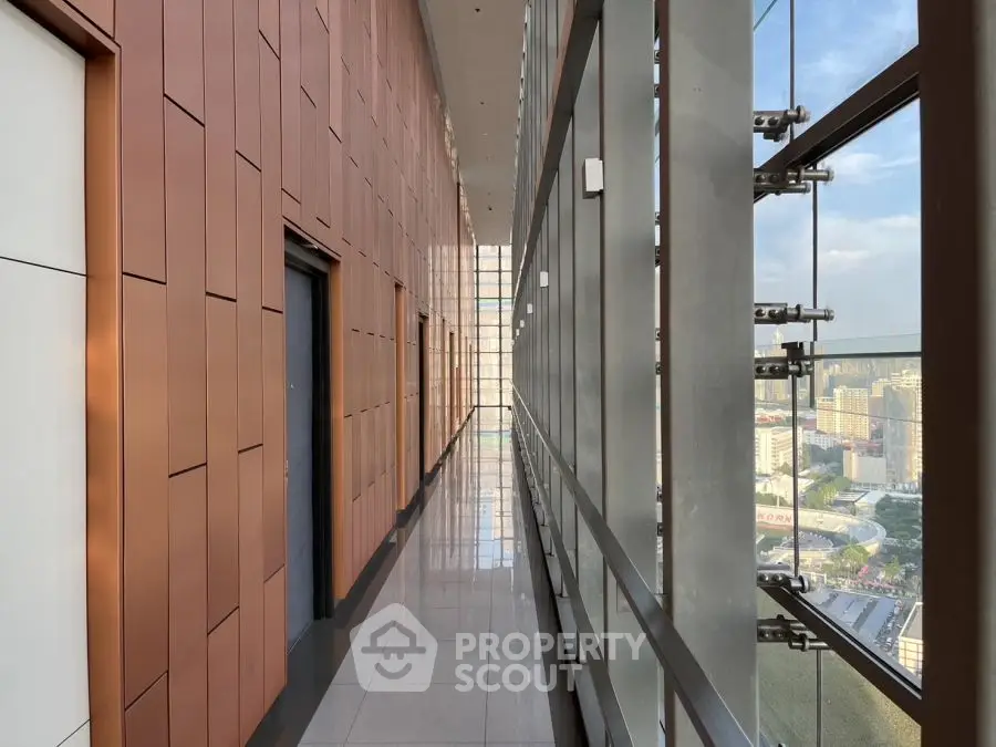 Modern high-rise building corridor with panoramic city views and sleek design.