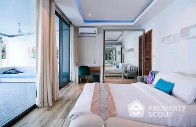 Luxurious bedroom with large glass doors opening to a spacious balcony, modern decor and cozy ambiance.