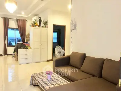 Spacious living room with modern sofa and natural light, perfect for relaxation and entertaining.