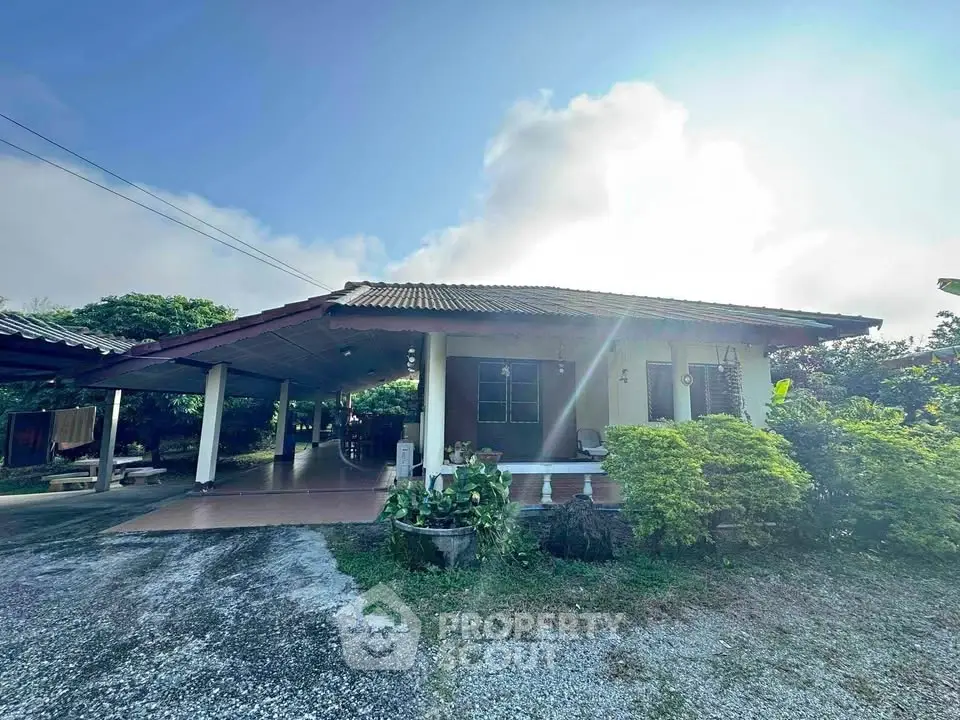 Charming single-story home with spacious driveway and lush greenery, perfect for serene living.