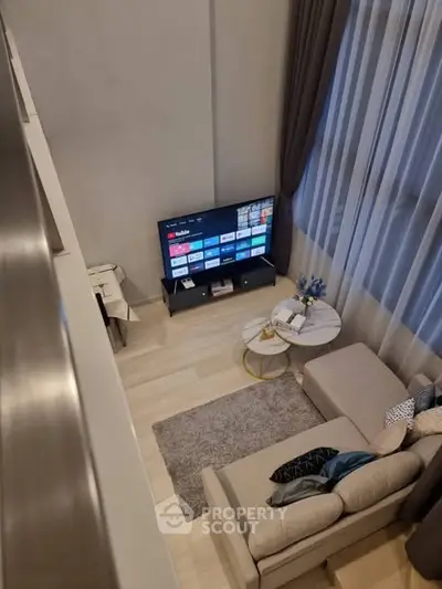 Modern living room with cozy sectional sofa and large TV, perfect for relaxation.