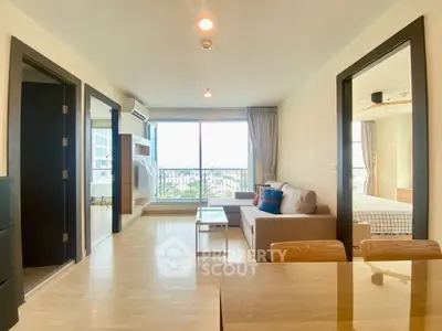 Spacious modern living room with large windows and stylish decor in a high-rise apartment.