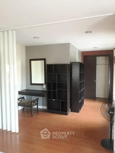 Spacious study area with modern shelving and elegant wooden flooring