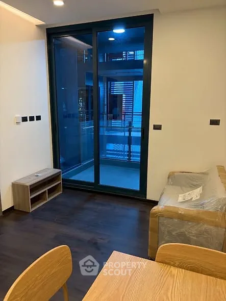 Modern living room with balcony access and stylish wooden furniture.