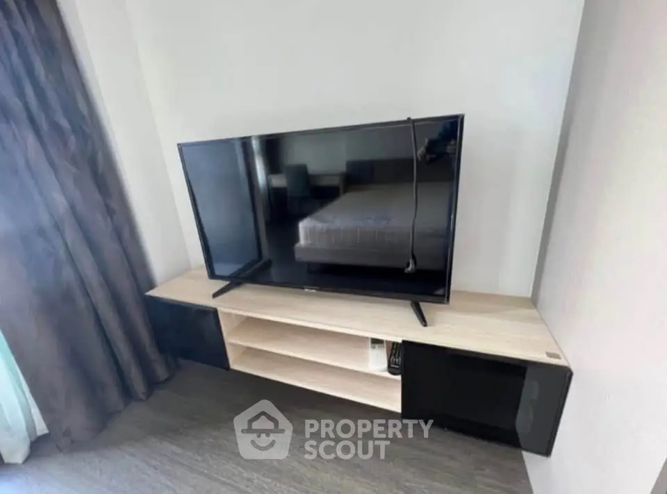 Modern living room with sleek TV stand and large flat-screen TV, perfect for entertainment.