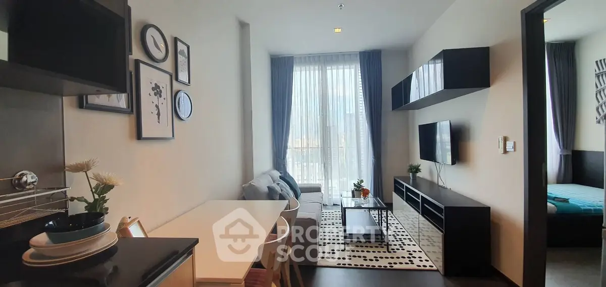 Modern living room with stylish decor and natural light, featuring a cozy seating area and wall-mounted TV.