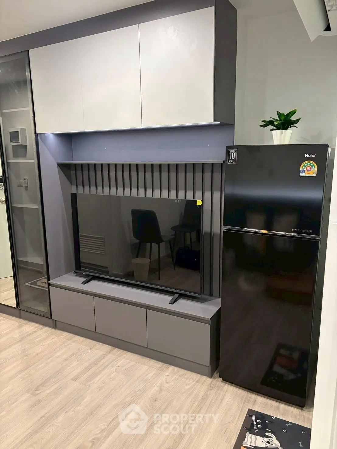 Modern living room with sleek TV unit and stylish black refrigerator