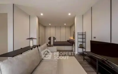 Modern living room with sleek design and neutral tones, featuring a comfortable sofa and stylish decor.