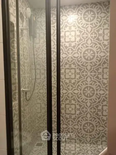 Stylish bathroom shower with elegant patterned tiles and modern glass enclosure.
