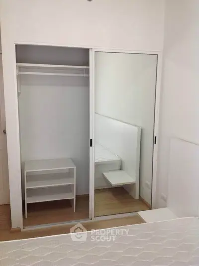 Modern bedroom with sliding mirrored closet doors and minimalist design.