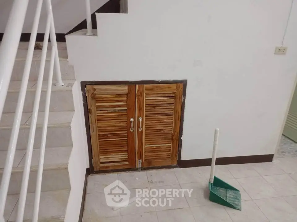 Unique under-stair storage with wooden doors in a modern home interior