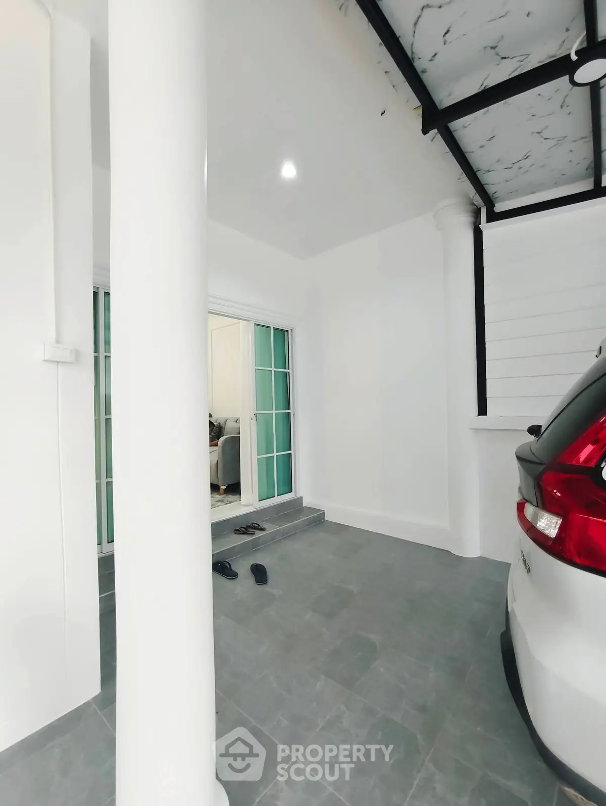 Modern home entrance with sleek carport and glass sliding doors