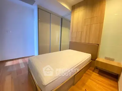 Modern bedroom with wooden flooring and built-in wardrobe