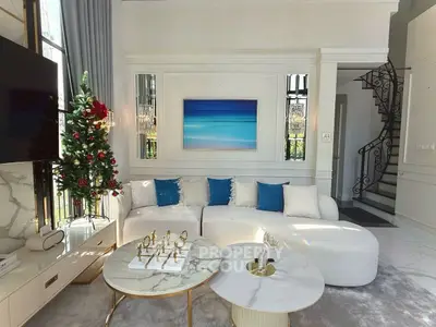 Luxurious living room with elegant decor and Christmas tree, featuring modern furniture and stylish staircase.