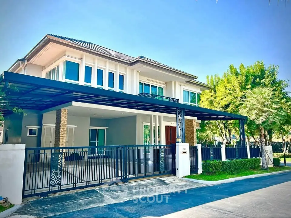 Stunning modern two-story house with spacious driveway and lush greenery, perfect for luxurious living.