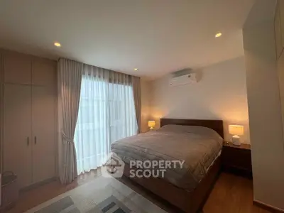 Cozy bedroom with large window and modern furnishings