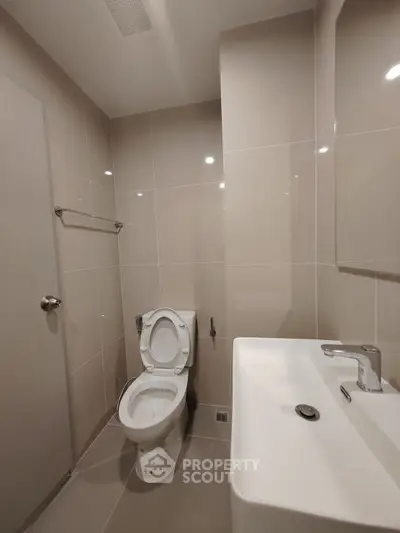 Modern bathroom with sleek fixtures and neutral tiles, perfect for a contemporary home.