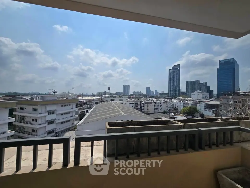 Stunning cityscape view from a high-rise balcony with modern buildings and clear skies.