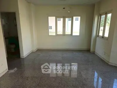 Spacious unfurnished room with large windows and glossy floor, ideal for customization.
