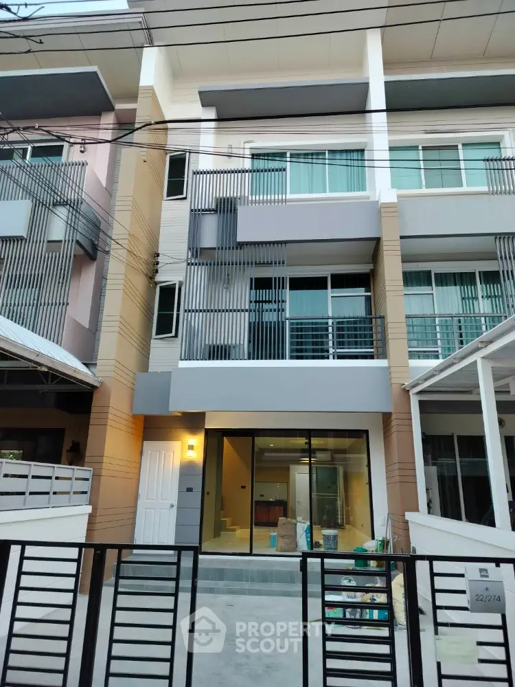 Modern three-story townhouse with sleek facade and large windows for sale