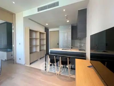 Modern open-layout kitchen with sleek cabinetry and breakfast bar in stylish apartment.