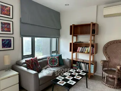 Charming living room with cozy sofa, stylish bookshelf, and large window offering natural light.